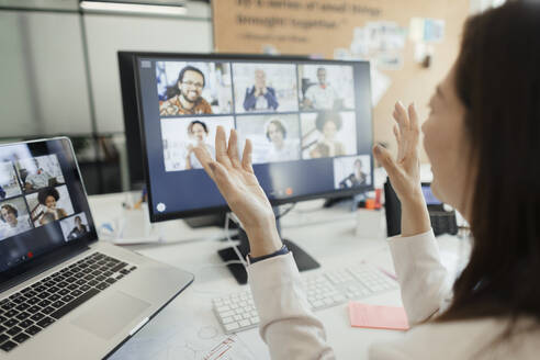 Businesswoman video conferencing with coworkers at computer screen - CAIF30397