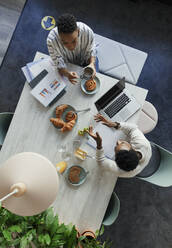 Business people meeting over breakfast at office table - CAIF30399
