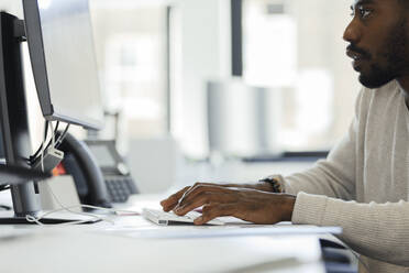 Geschäftsmann arbeitet am Computer im Büro - CAIF30408