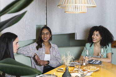 Geschäftsfrauen, die im Restaurant sitzen und diskutieren - PNAF01747