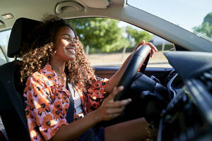 Smiling young woman driving car - KIJF03886
