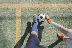 Vater und Sohn spielen Fußball auf dem Sportplatz - MMFF01314