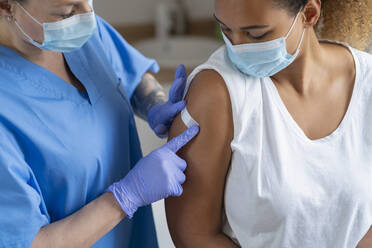 Krankenschwester beim Anlegen eines Verbandes am Arm eines Patienten in einer medizinischen Klinik - SNF01470