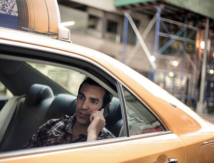 Junger Mann benutzt Mobiltelefon im Taxi - AJOF01370