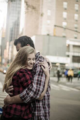 Zärtliches junges Paar umarmt sich auf der Straße in der Stadt - AJOF01377