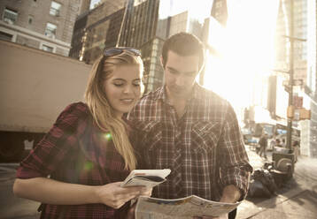 Junges Paar betrachtet Stadtplan in der Stadt - AJOF01391