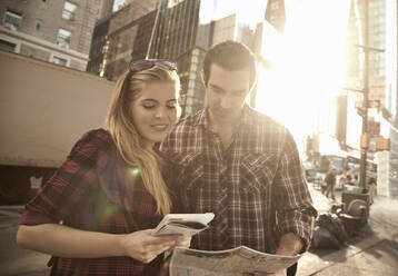 Young couple looking at map in city - AJOF01391