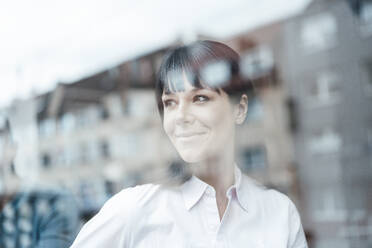 Female entrepreneur looking through window at cafe - JOSEF04571