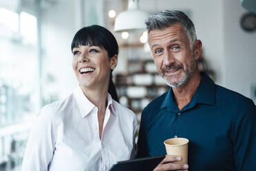 Smiling business couple standing together at coffee shop - JOSEF04607