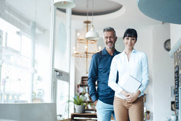 Smiling male and female owners standing at coffee shop - JOSEF04622