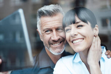 Smiling business couple taking selfie through digital tablet at cafe - JOSEF04636