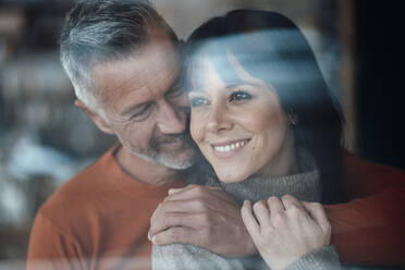 Mature man with arm around on woman smiling at cafe - JOSEF04640