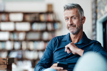 Mature male entrepreneur with mobile phone at cafe - JOSEF04744