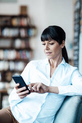 Female owner using smart phone while sitting at cafe - JOSEF04751