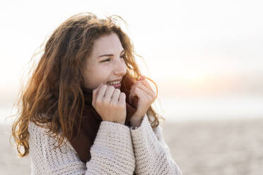 Junge Frau mit rothaarigem Kopftuch am Strand - SBOF03885