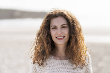 Schöne rothaarige Frau lächelnd am Strand - SBOF03886