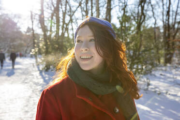 Lächelnde Frau mit Kopftuch, die an einem sonnigen Tag wegschaut - FVDF00176
