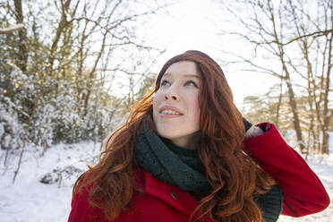 Redhead woman looking up while enjoying winter - FVDF00177