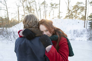 Boyfriend embracing girlfriend during winter - FVDF00200