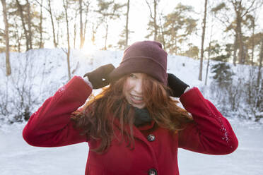 Glückliche Frau mit Strickmütze im Winter - FVDF00204