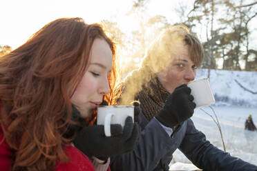 Young couple drinking coffee during winter - FVDF00210