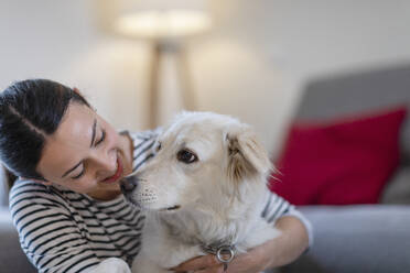Junge Besitzerin umarmt süßen Hund zu Hause - EIF01126