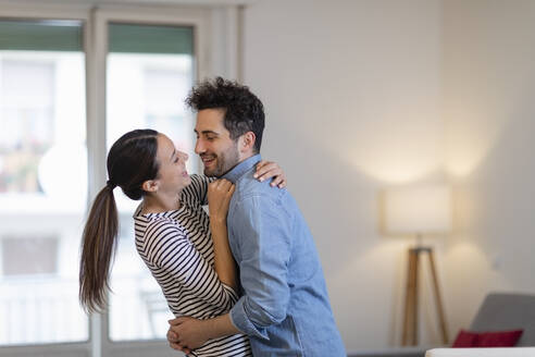 Glückliches Paar tanzt zusammen im Wohnzimmer zu Hause - EIF01127
