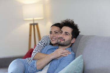 Lächelnde Paar Tag träumen zusammen, während auf dem Sofa im Wohnzimmer sitzen - EIF01141