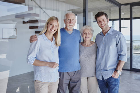 Glückliche Familie, die gemeinsam vor einer Glaswand steht - RORF02780