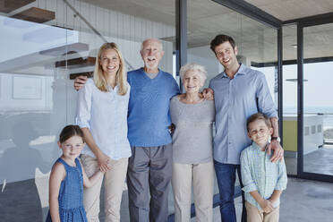 Glückliche Mehrgenerationenfamilie vor einer Glaswand - RORF02785