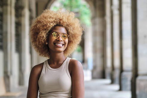 Smiling Afro woman wearing heart shaped sunglasses - AGOF00117