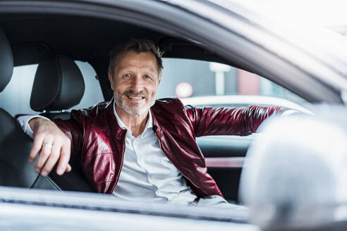 Mature man smiling while sitting in car - DIGF15662