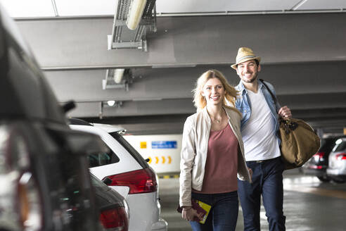 Junges Paar geht über einen Flughafenparkplatz - AUF00719