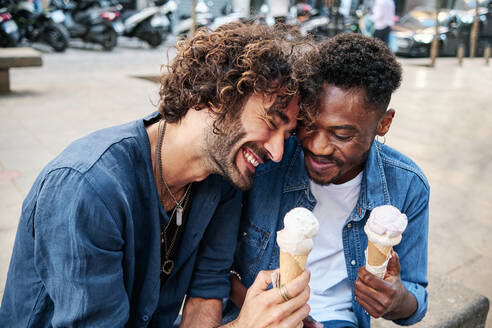Happy gay couple enjoying ice cream - AGOF00133