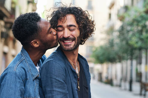 Affectionate gay man kissing happy boyfriend - AGOF00141