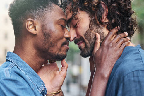 Gay couple with eyes closed doing romance - AGOF00143