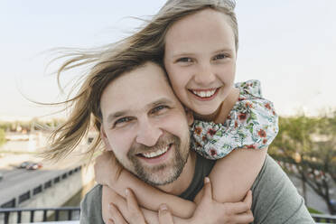 Happy daughter embracing father carrying her piggyback - EYAF01613