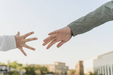 Hands of father and daughter reaching for each other - EYAF01615