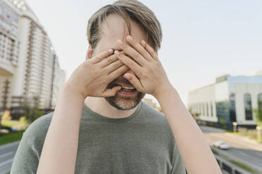 Die Hand der Tochter bedeckt die Augen des Vaters - EYAF01618