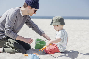 Father and son playing together with sand toys at beach - ACTF00047