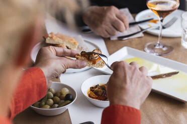 Männliche und weibliche Freunde beim Essen im Restaurant - PNAF01774