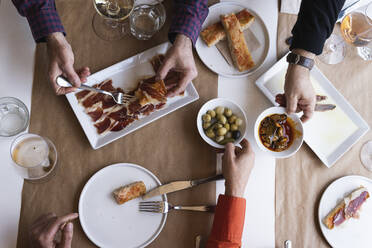 Männliche und weibliche Freunde beim Essen am Tisch im Restaurant - PNAF01788