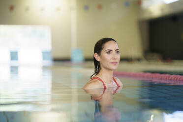 Reife Frau schaut im Schwimmbadwasser im Club weg - JSMF02230