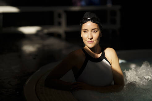 Reife Frau mit Sonnenlicht auf dem Gesicht im Schwimmbad - JSMF02254