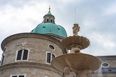 Österreich, Land Salzburg, Salzburg, Residenzbrunnen mit Kuppel des Salzburger Doms im Hintergrund - TAMF03073