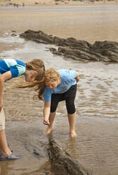 Curious friends playing at beach - AJOF01413