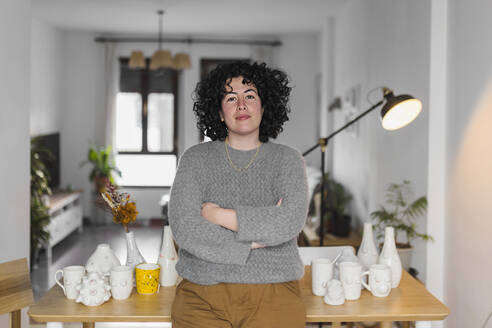 Female mid adult artist standing with arms crossed at workshop - ASSF00112