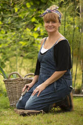 Portrait glückliche Frau bei der Gartenarbeit im Hinterhof - CAIF30576