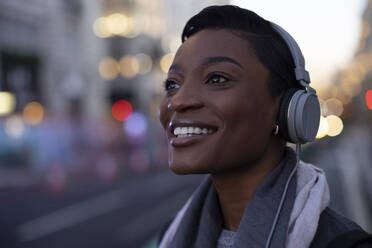 Nahaufnahme Porträt glückliche junge Frau mit Kopfhörern in der Stadt Straße - CAIF30625