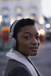 Nahaufnahme Porträt selbstbewusste junge Frau mit Kopfhörern - CAIF30629